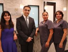 Dr. & Mrs. Azadi with staff at office reception desk 